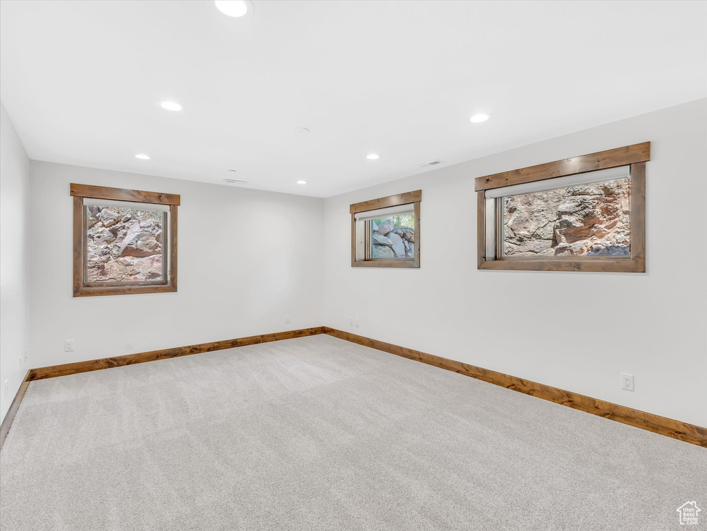 Carpeted spare room featuring baseboards and recessed lighting