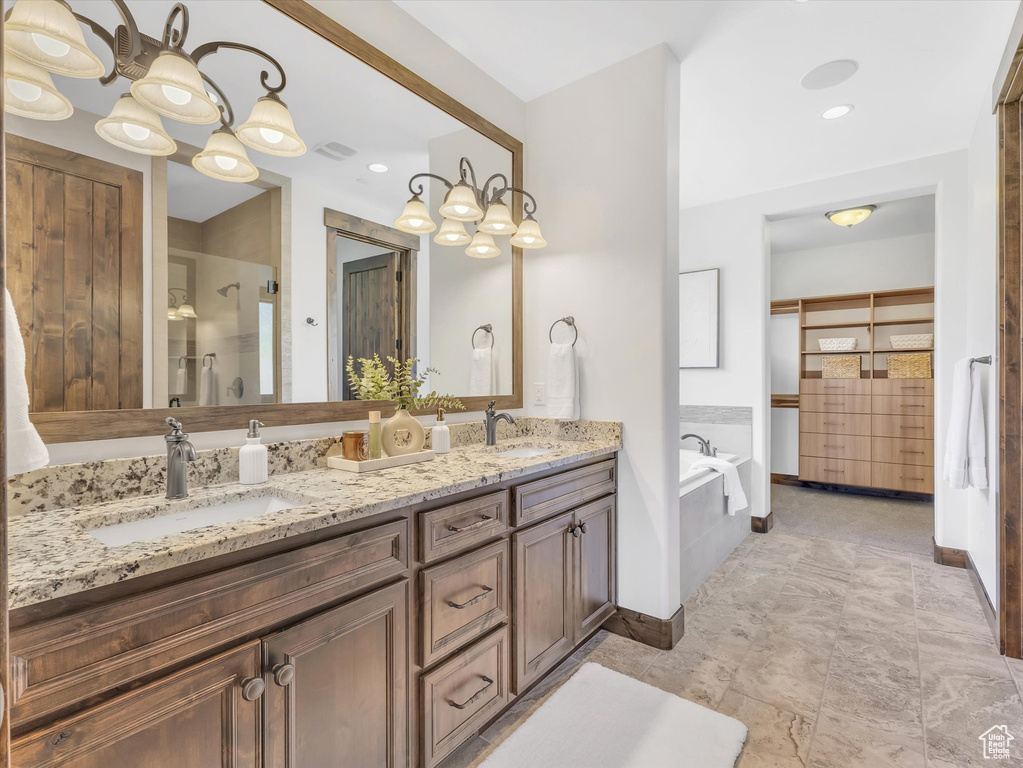 Bathroom featuring double vanity, a garden tub, and a shower stall