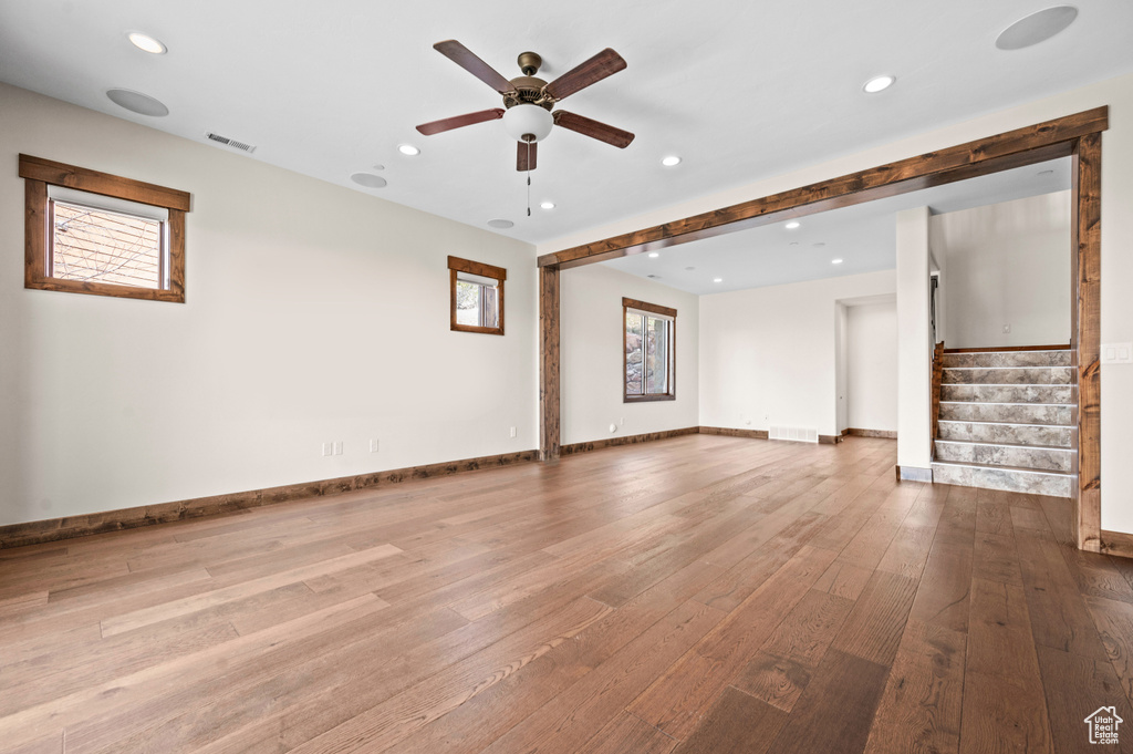 Unfurnished living room with ceiling fan, light hardwood / wood-style flooring, and a wealth of natural light