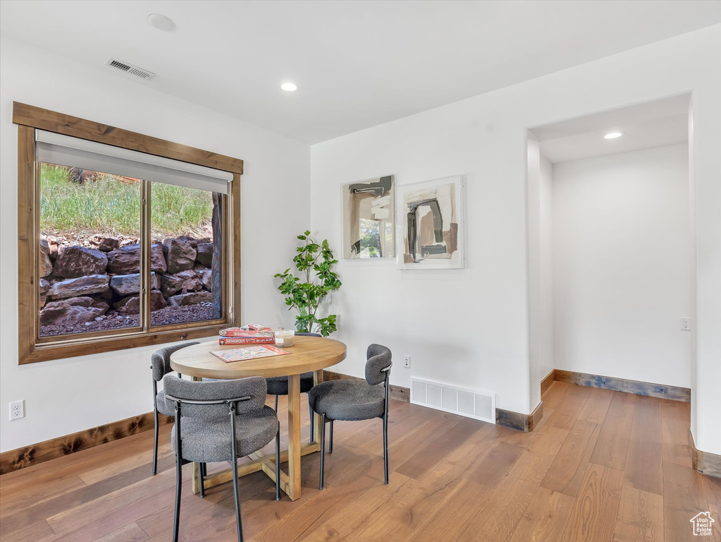 Dining room with wood finished floors, baseboards, and recessed lighting