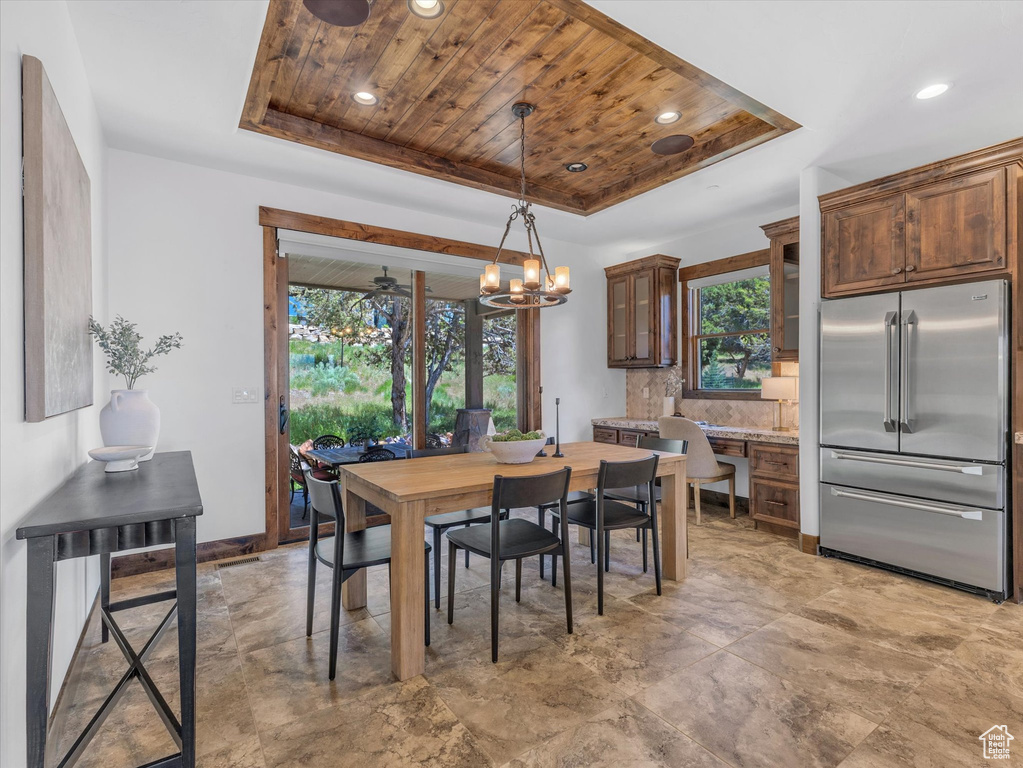 Dining room featuring a raised ceiling, wood ceiling, a chandelier, and recessed lighting