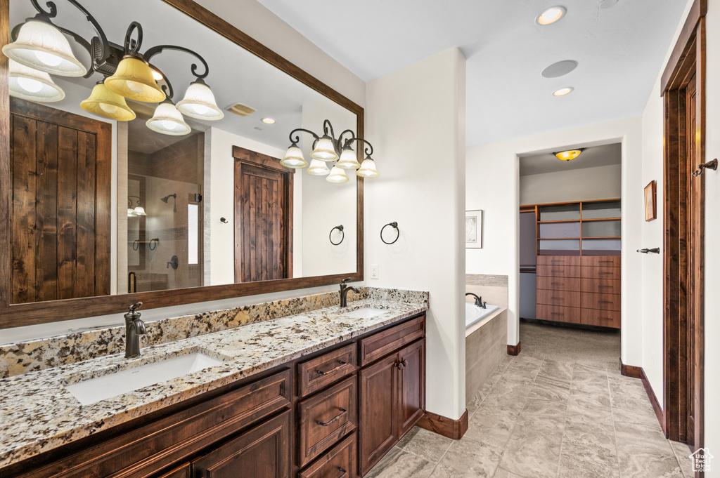 Bathroom featuring dual sinks, tile floors, separate shower and tub, and oversized vanity