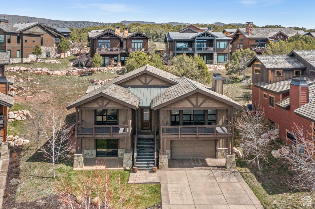 View of front of house featuring a mountain view, a balcony, and a garage