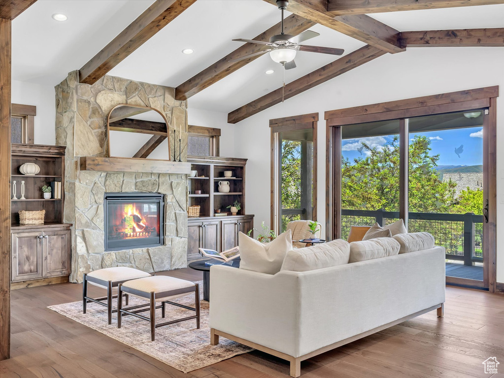 Living room featuring ceiling fan, wood finished floors, recessed lighting, and a fireplace