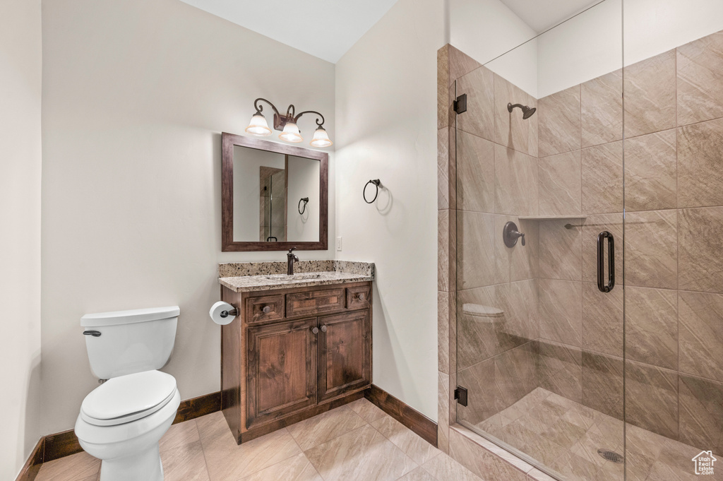 Bathroom featuring walk in shower, toilet, large vanity, and tile floors