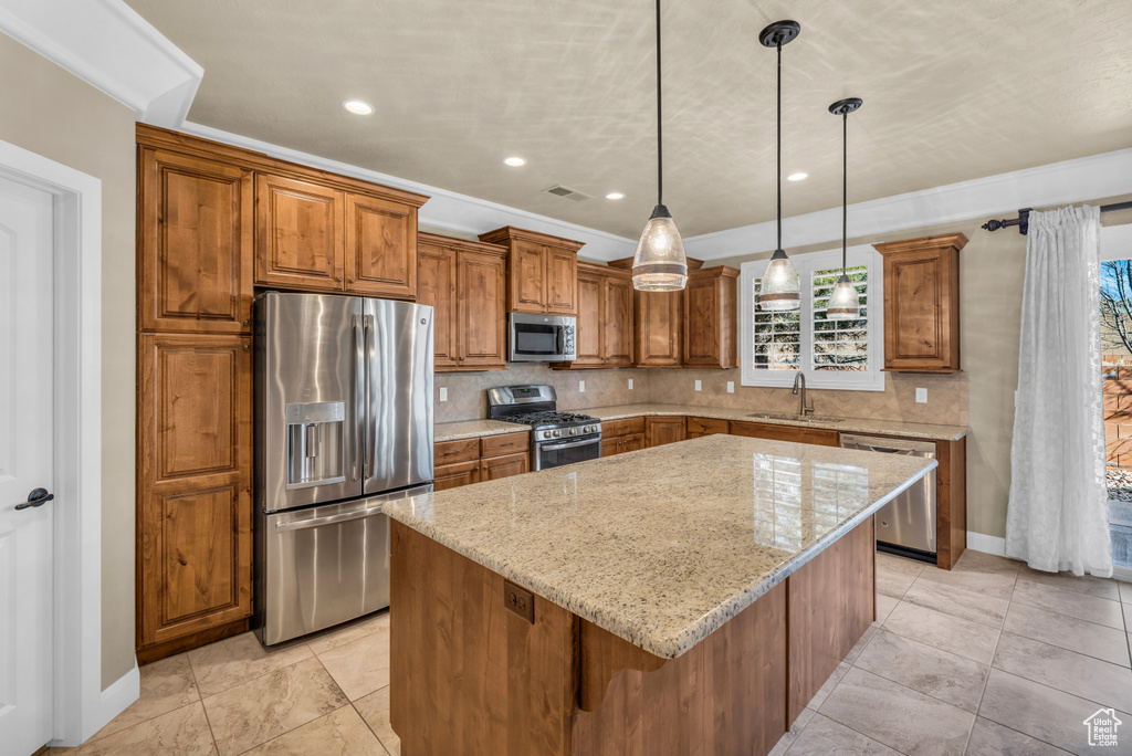 Kitchen with appliances with stainless steel finishes, backsplash, a center island, and a healthy amount of sunlight