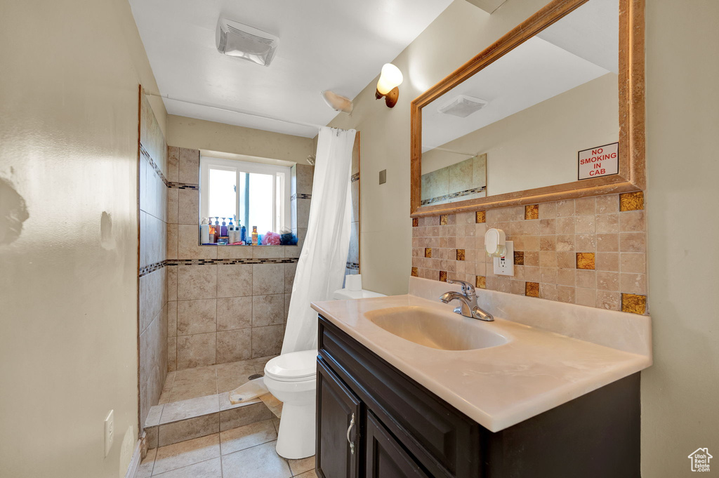 Bathroom featuring large vanity, backsplash, tile flooring, toilet, and a shower with curtain