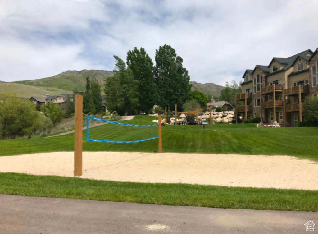 Surrounding community with volleyball court, a lawn, and a mountain view