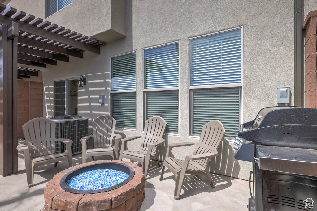 View of patio with a pergola, grilling area, a fire pit, and central air condition unit