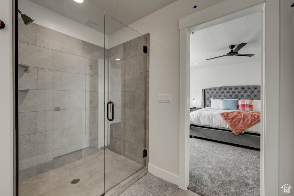 Bathroom with ceiling fan and a shower with shower door