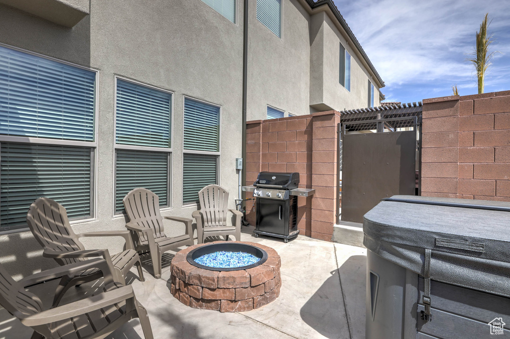 View of patio with an outdoor fire pit and grilling area