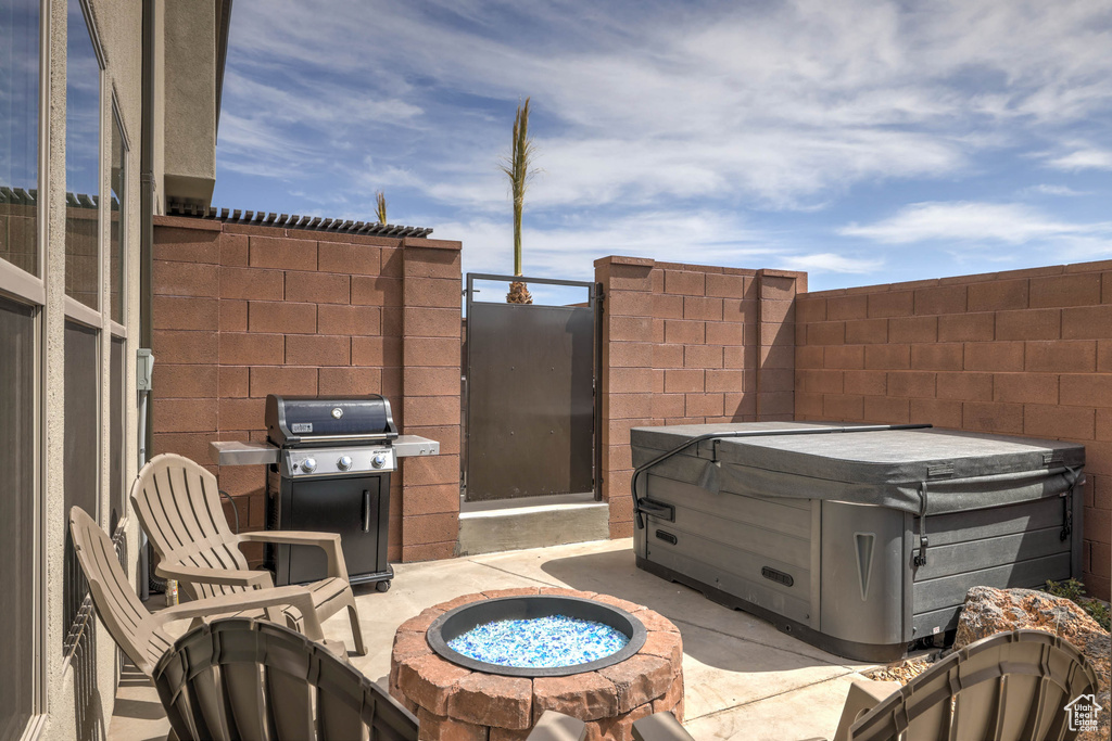 View of patio / terrace featuring grilling area, an outdoor fire pit, and a hot tub