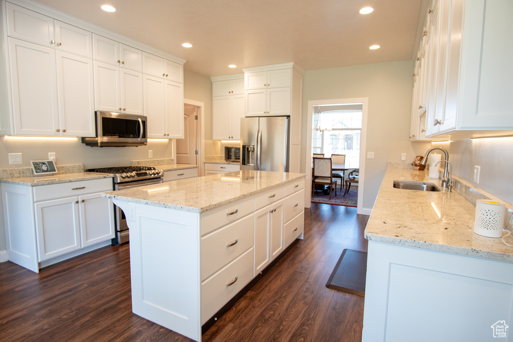 Kitchen featuring dark hardwood / wood-style floors, stainless steel appliances, white cabinetry, and sink
