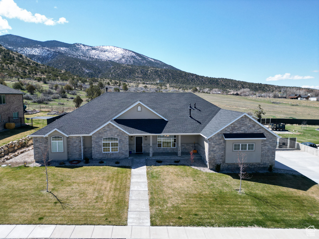 Single story home featuring a front lawn and a mountain view