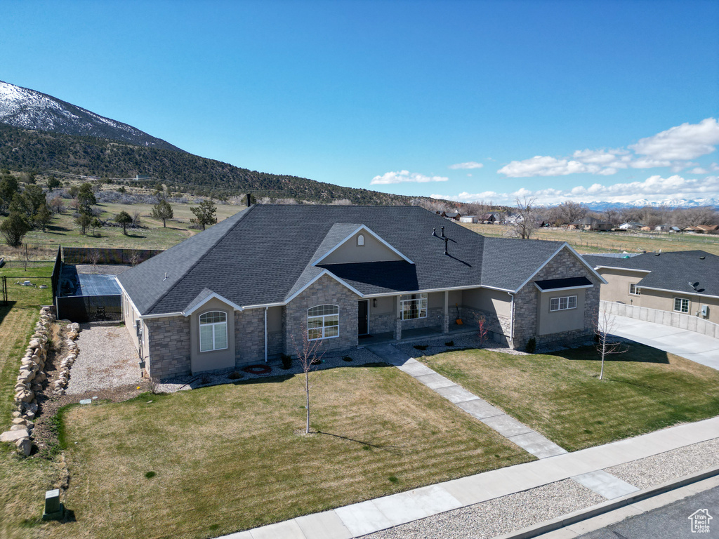 Ranch-style home with a mountain view and a front lawn