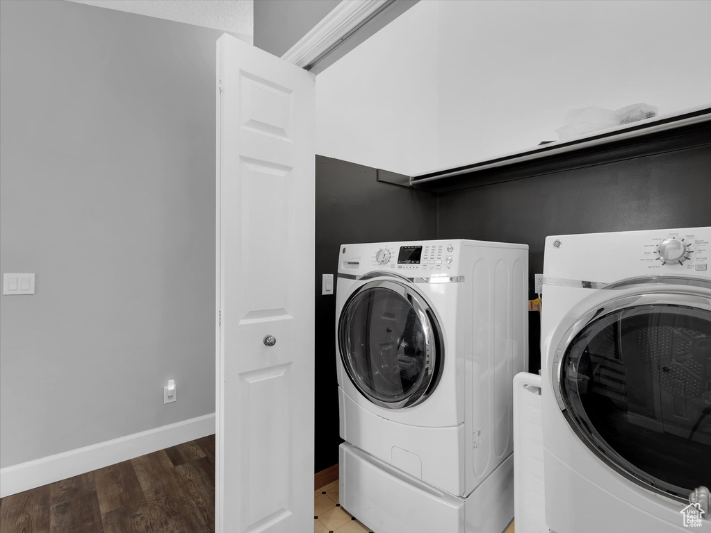 Laundry area with washer and dryer and dark hardwood / wood-style flooring