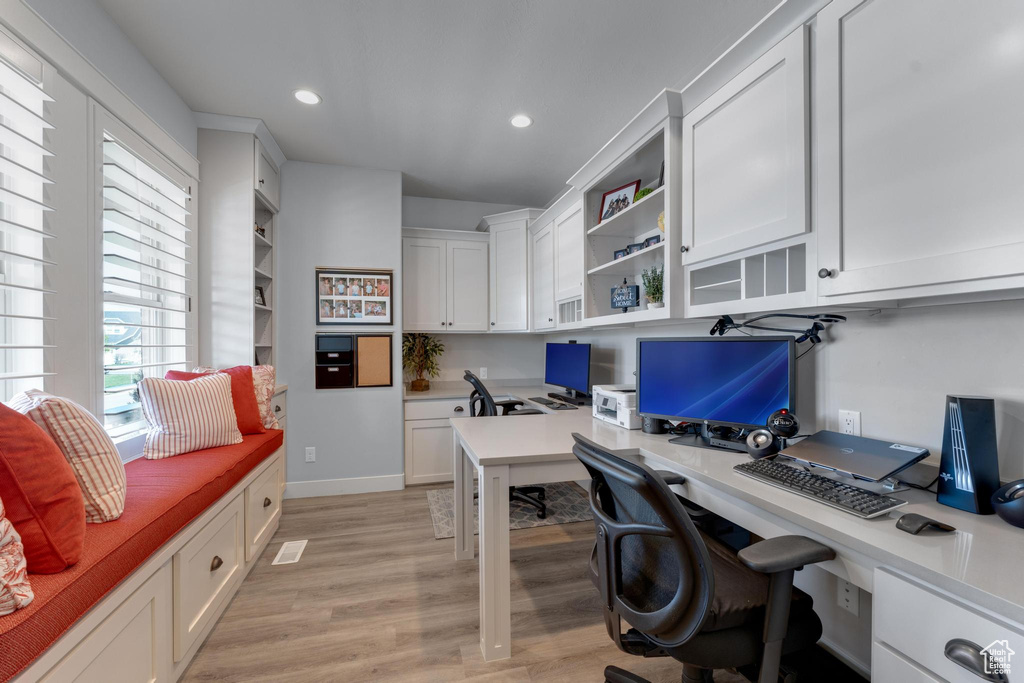 Home office featuring light hardwood / wood-style flooring and built in desk