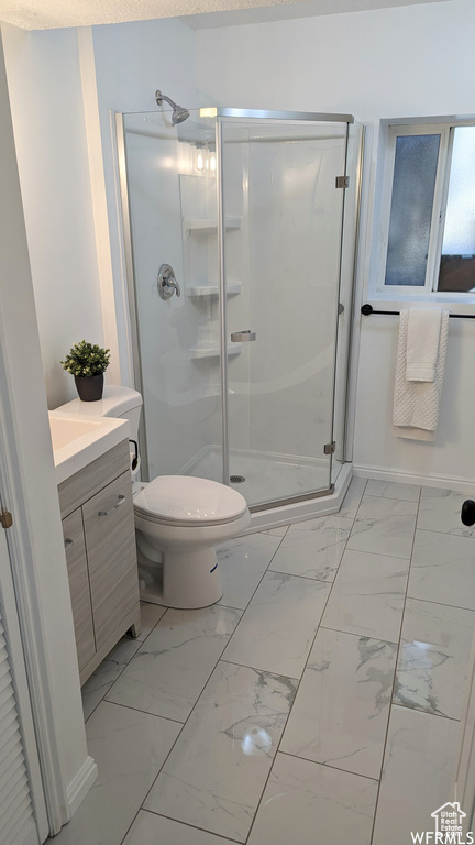 Bathroom with vanity, tile floors, a shower with door, and toilet