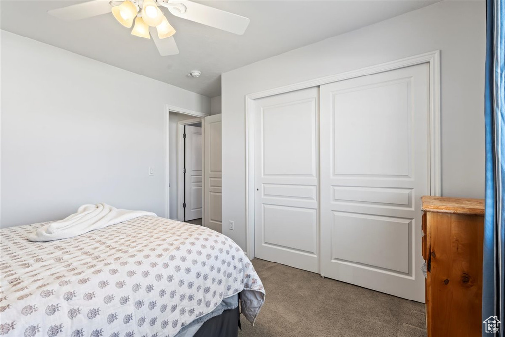 Bedroom featuring light carpet, a closet, and ceiling fan