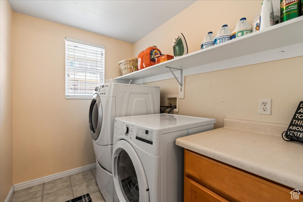 Washroom featuring light tile floors, hookup for a washing machine, and separate washer and dryer