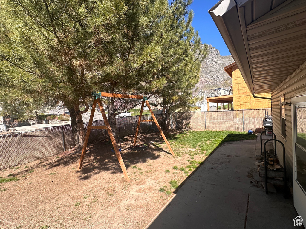 View of yard featuring a patio, a mountain view, and a playground