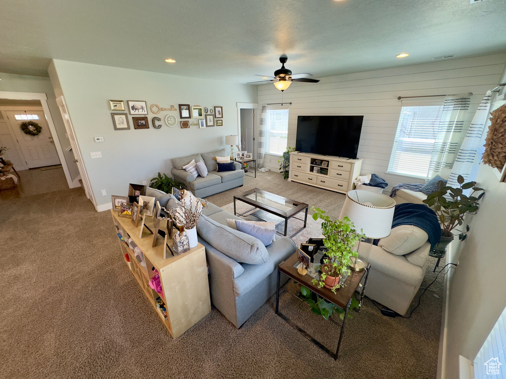 Living room with ceiling fan and light carpet