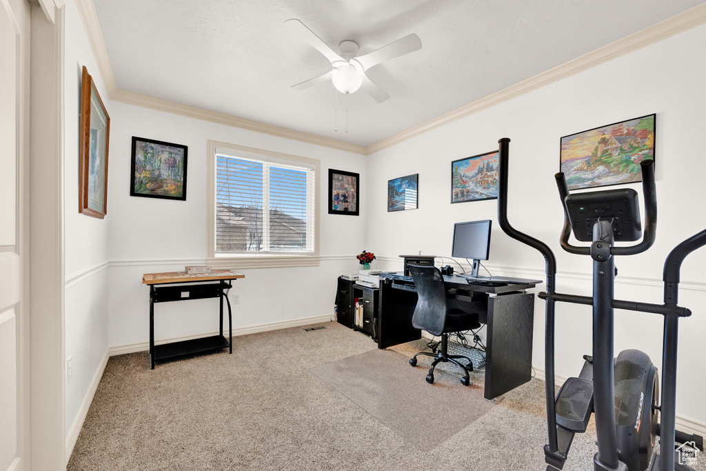 Home office featuring ornamental molding, light colored carpet, and ceiling fan