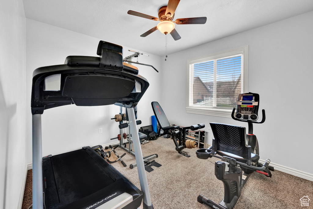 Workout area with ceiling fan and carpet