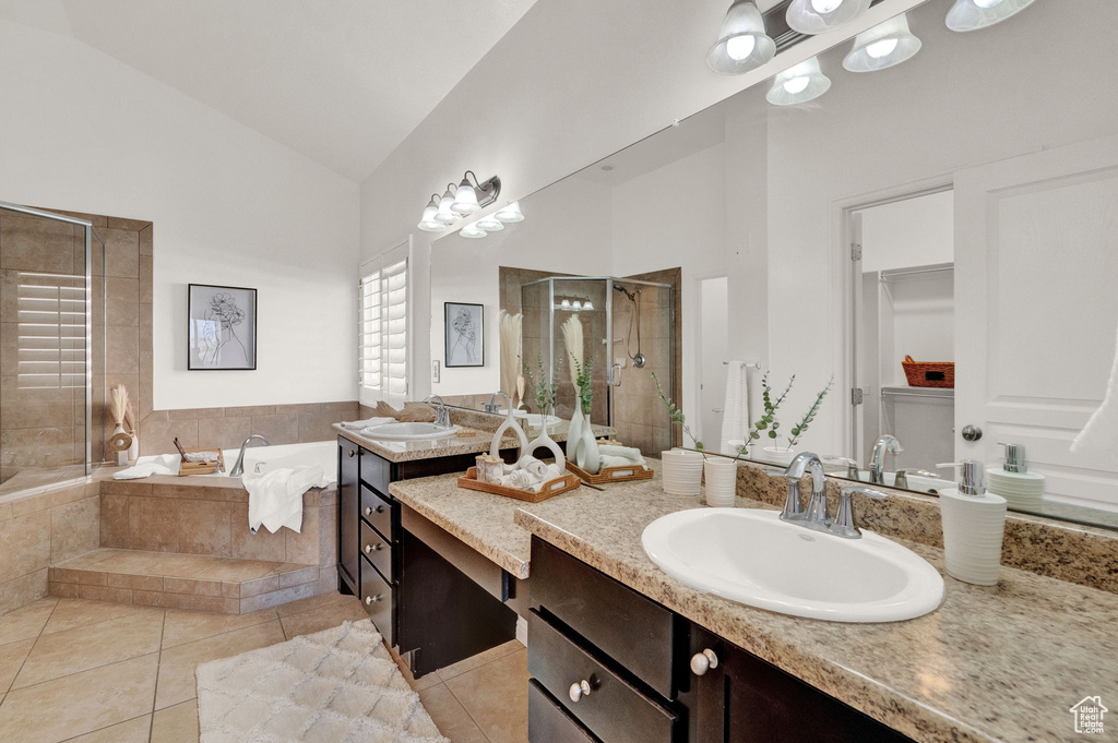 Bathroom featuring high vaulted ceiling, plus walk in shower, vanity, and tile floors