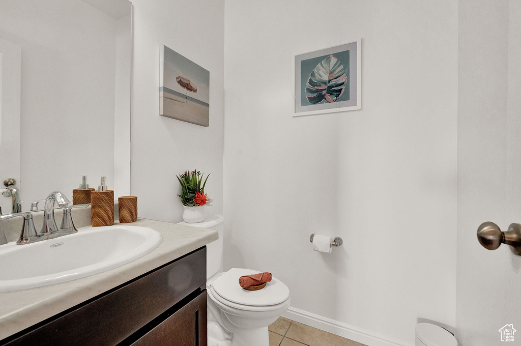 Bathroom featuring large vanity, tile floors, and toilet