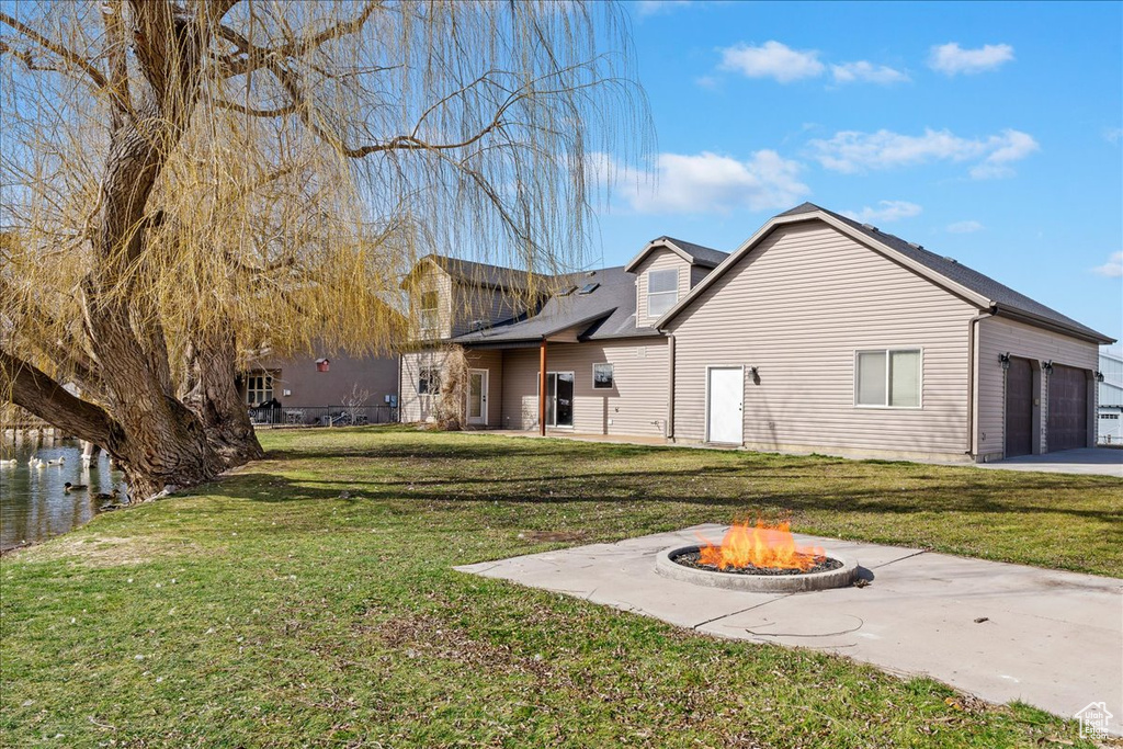 Back of house featuring a fire pit and a yard
