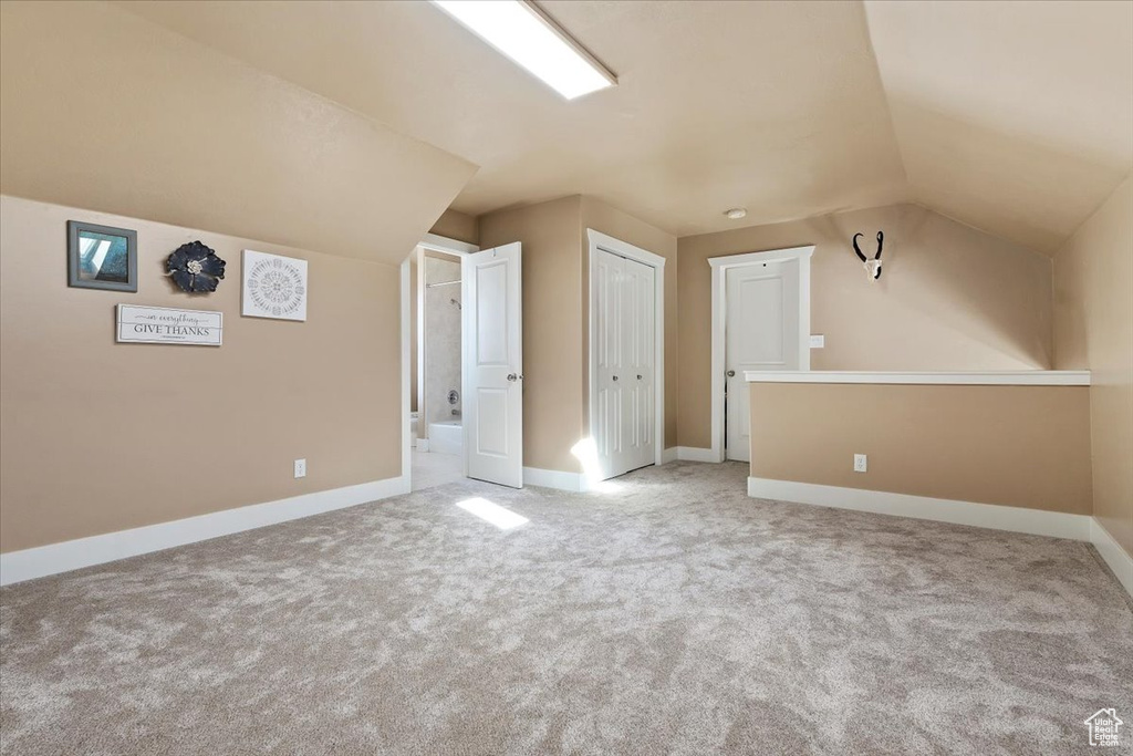 Bonus room featuring lofted ceiling and light carpet