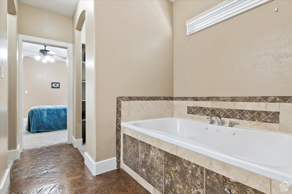 Bathroom with a relaxing tiled bath and ceiling fan