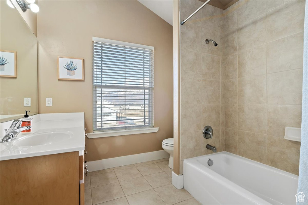 Full bathroom with tiled shower / bath combo, vanity, a healthy amount of sunlight, and toilet
