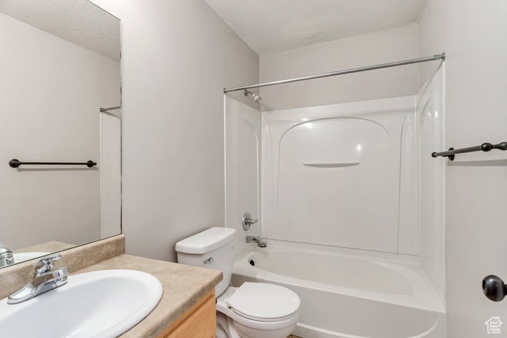 Full bathroom with toilet, washtub / shower combination, and vanity
