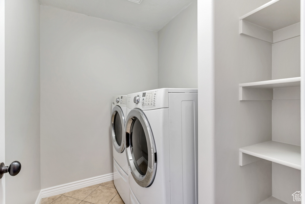 Laundry area featuring washer and clothes dryer and light tile flooring