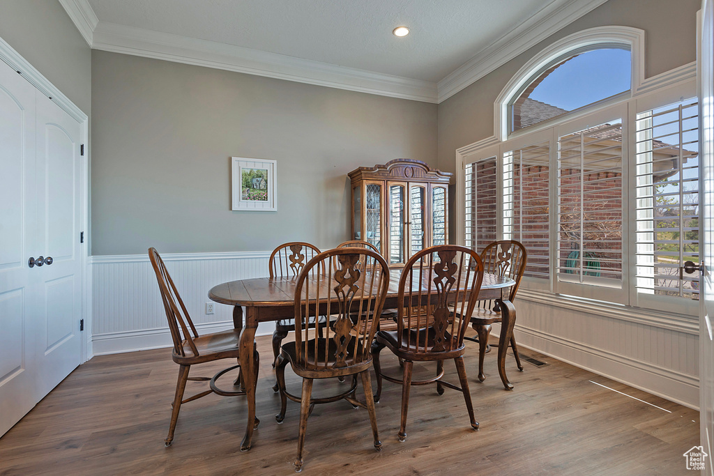 Dining area featuring ornamental molding and dark hardwood / wood-style floors