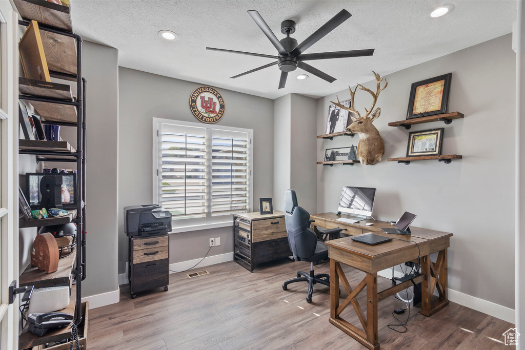Home office featuring ceiling fan, a textured ceiling, and hardwood / wood-style floors