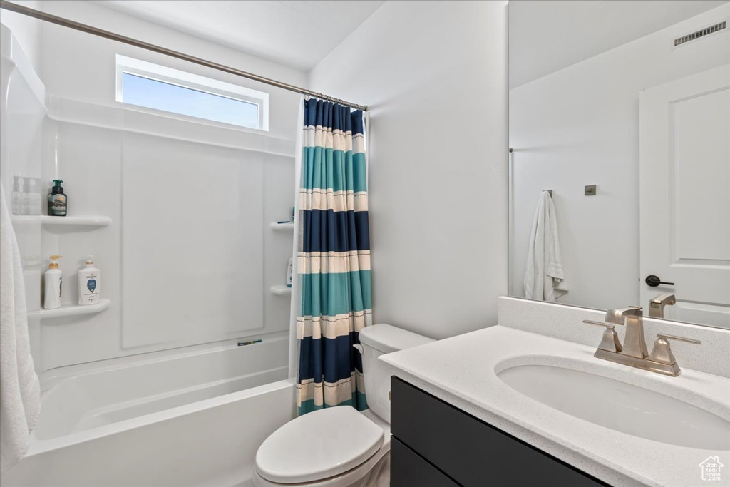 Full bathroom featuring shower / bathtub combination with curtain, toilet, and oversized vanity
