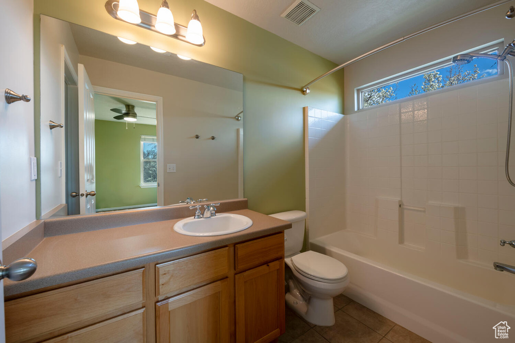 Full bathroom featuring shower / tub combination, tile floors, vanity, toilet, and ceiling fan