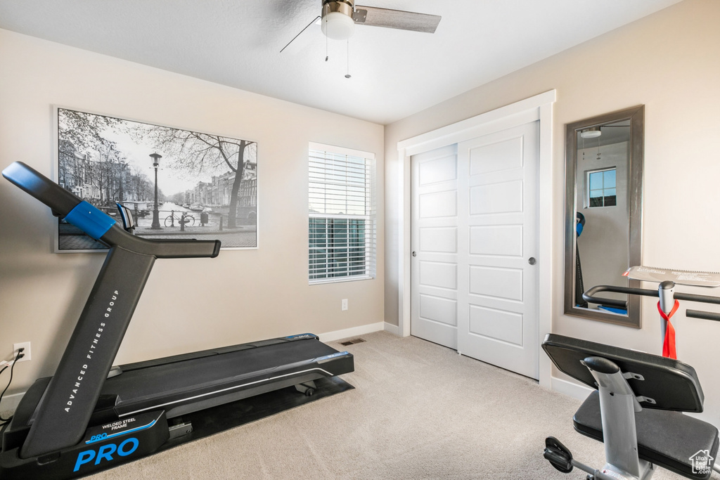 Exercise room featuring ceiling fan and light colored carpet