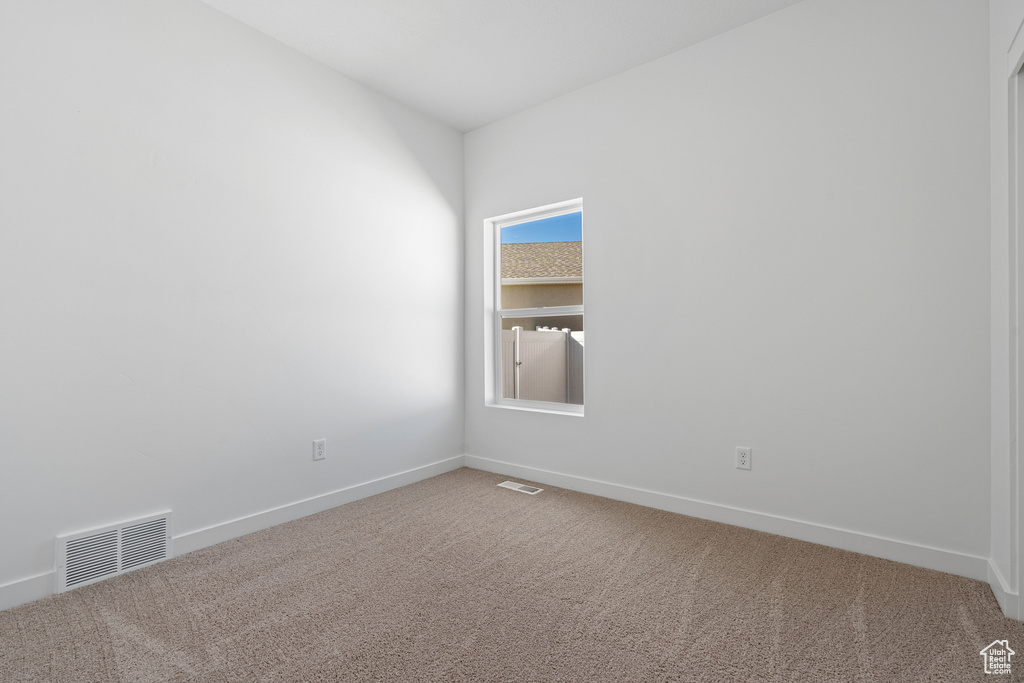 Spare room featuring light colored carpet and plenty of natural light