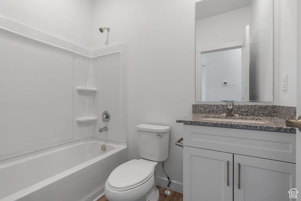 Full bathroom featuring vanity with extensive cabinet space, hardwood / wood-style flooring, toilet, and bathing tub / shower combination