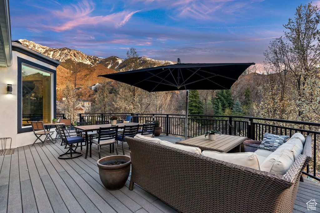 Deck at dusk featuring a mountain view and an outdoor hangout area