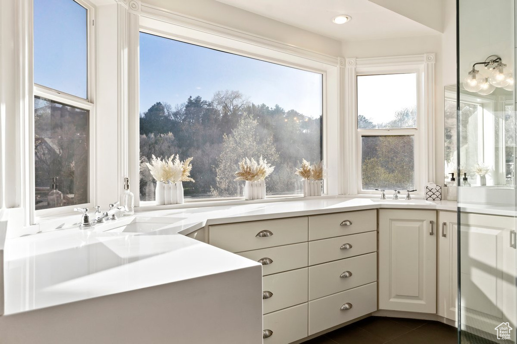 Bathroom with tile flooring, large vanity, and a wealth of natural light