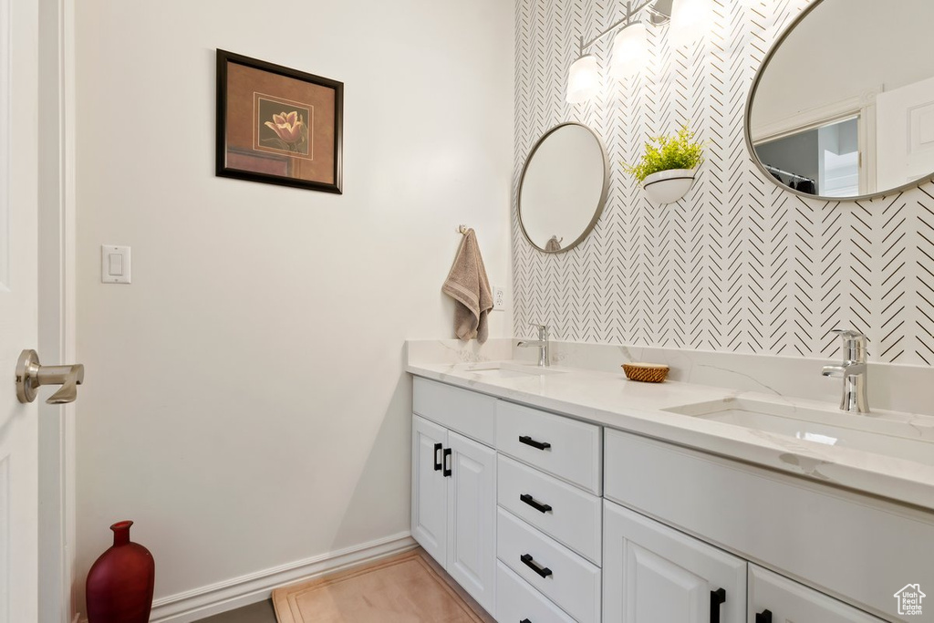 Bathroom featuring vanity with extensive cabinet space and double sink