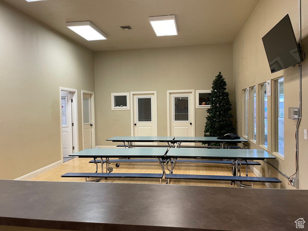 Workout room with hardwood / wood-style floors and a towering ceiling