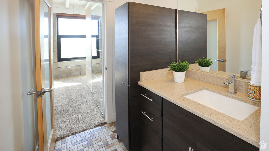 Bathroom featuring tile floors, vanity, and a shower with door