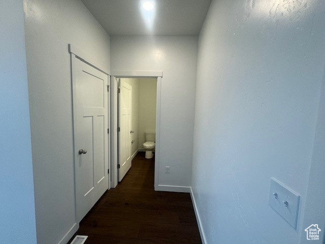Hallway with dark hardwood / wood-style flooring
