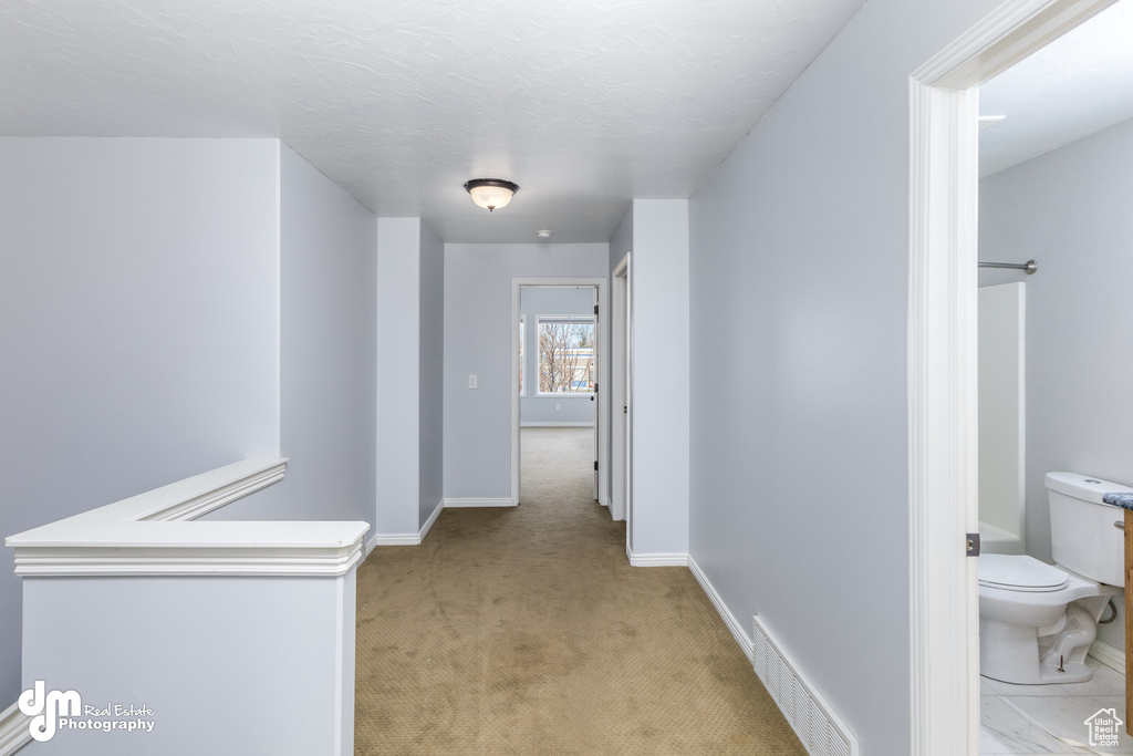 Corridor with light colored carpet